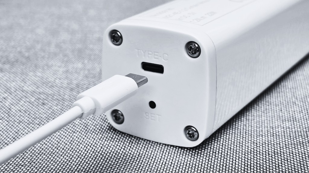 USB-C charging port and SET button on the end of the white Novo N21 motor, with cable ready to connect