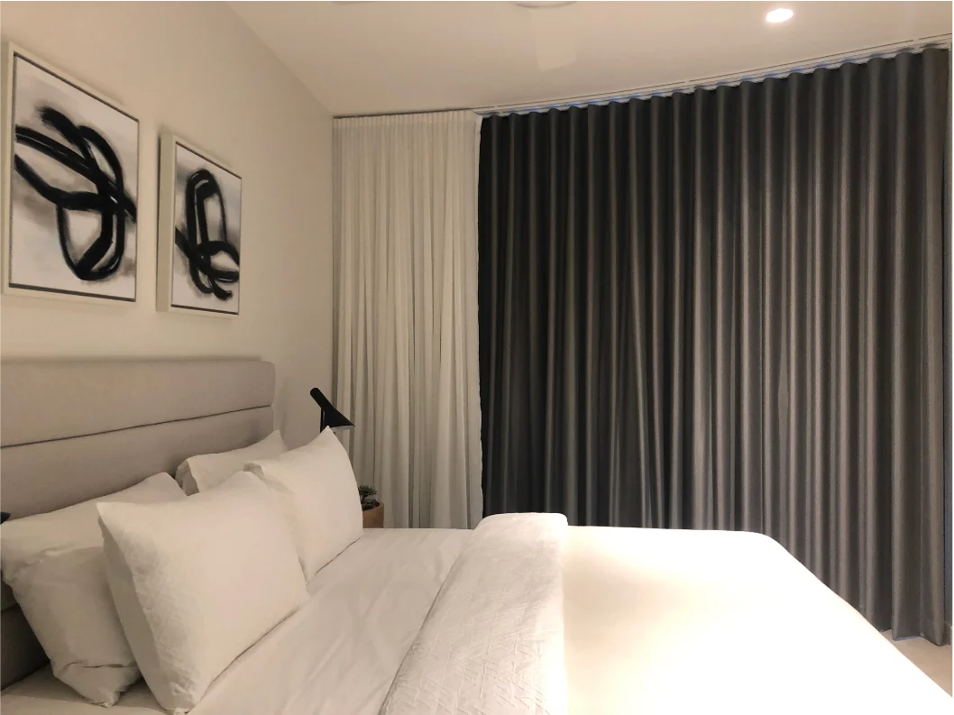 Floor-to-ceiling charcoal blockout curtains with S-fold heading and white sheer layer in a modern bedroom - Southport